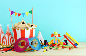 Purim celebration concept (jewish carnival holiday) over wooden table