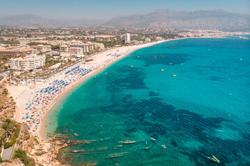 Fototapeta premium Spanish Mediterranean Sea Coast Landscape. Beach with turquoise water. Touristic sun and beach landmark in Playa del Albir, Comunidad Valenciana, Spain