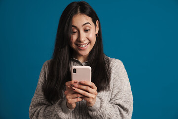 Happy beautiful asian girl smiling and using smartphone