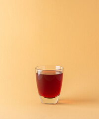 Delicious sweet red pomegranate juice in glass isolated on beige background