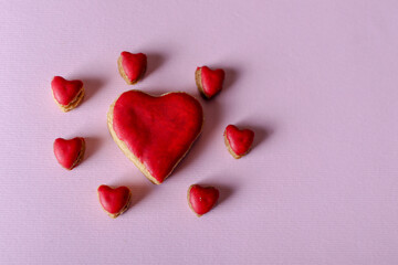 Big red heart cookie and little cookies around isolated on purple background with copy space for text or design. Valentines day and love concept