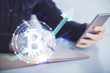 Double exposure of blockchain business sketch hologram and woman holding and using a mobile device.