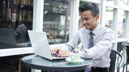 young Asian entrepreneurs looking at laptop