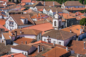 Fototapeta na wymiar View of orange roofs and white small buildings in a picturesque town. Trancoso, Portugal.