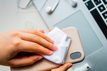 Cleaning the case of the mobile phone. Coronavirus prevention, hygiene to stop spreading...