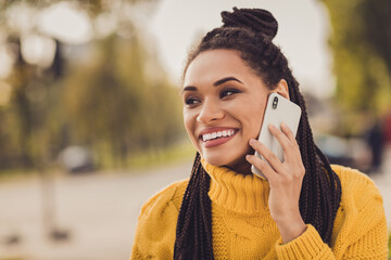 Portrait of young cheerful happy smiling positive dark skin woman talking on smartphone outside outdoors