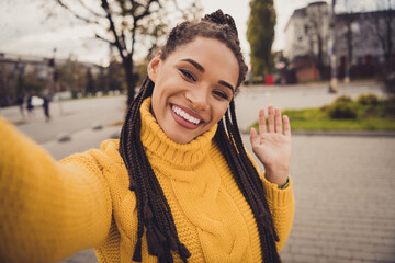 Portrait of young beautiful attractive smiling cheerful afro girl taking selfie saying hello outside outdoors