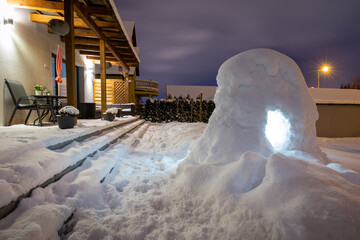 Beautiful winter garden terrace with snow igloo at night. Poland