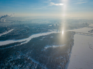Light pillar from the sun over the Dnieper river in Kiev. Aerial drone view. Winter sunny morning.