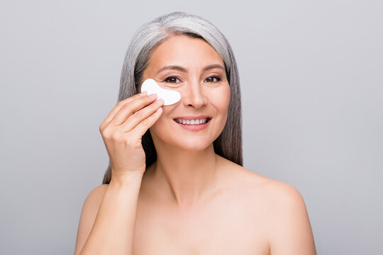 Photo of charming flawless perfect mature lady hold bag apply under eye shiny white smile isolated grey background