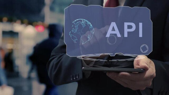 Unrecognizable businessman uses hologram on smartphone with text API. Man in shirt and jacket with holographic screen on background of entrance to the airport or train station