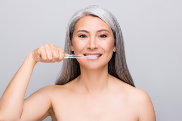 Portrait of optimistic nice long hair woman brush teeth without clothes isolated on light grey color background