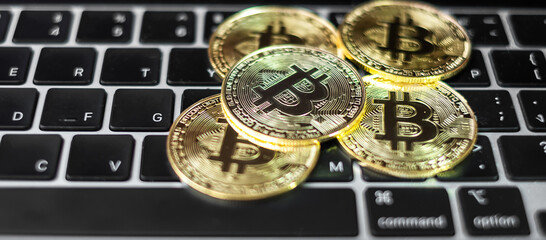 golden Bitcoin cryptocurrency coin stack on laptop keyboard, Crypto is Digital Money within the blockchain network, is exchanged using technology and online internet exchange. Financial concept