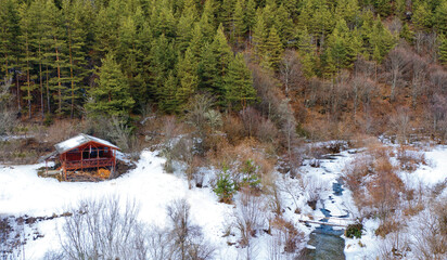 Aerial drone photo of wooden mountain hut in Rhodope mountains, on a beautiful winter day. Bird's eye perspective.