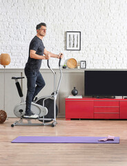 Fototapeta na wymiar Man is doing sport at home, fit male training style, decorative living room, brick wall sofa and television unit style.