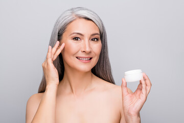 Portrait of optimistic nice long hair woman apply cream without clothes isolated on light grey color background