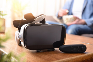 Vr headset and joystick controller on wooden table living room