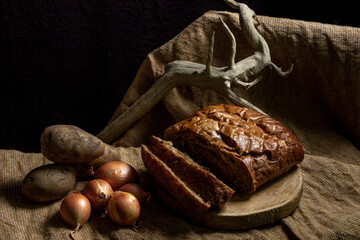 Black bread and vegetables on a black background. Borodino bread. Homemade baking. Bakery product. Peasant food