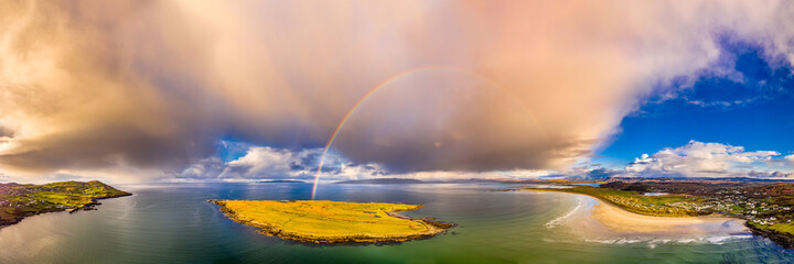 Aerial view of an rainbow above the Atlantic Ocean and Inishkeel by Portnoo in Donegal - Ireland