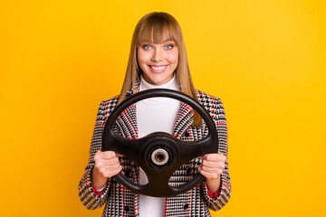 Fototapeta premium Photo of satisfied young girl arms holding wheel beaming smile look camera isolated on yellow color background
