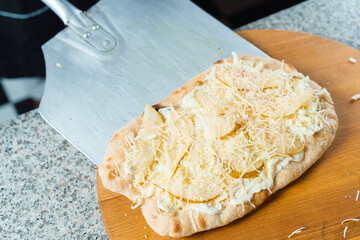 Chef cooking pinsa romana with pear, cheese, prosciutto in delivery box. Scrocchiarella gourmet italian cuisine. Traditional dish. Food delivery from pizzeria.