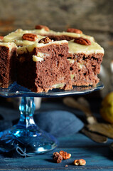 Chocolate cake with pieces of pear cut into pieces on a glass plateau