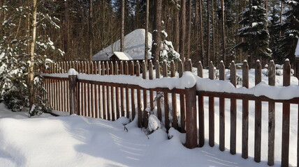 wooden fence and snow yard in village