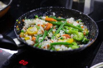 Foiled lined baking sheet filled with raw carrots, cauliflower, brussels sprouts, baby bell peppers coated in oil and spices to be roasted in the oven.