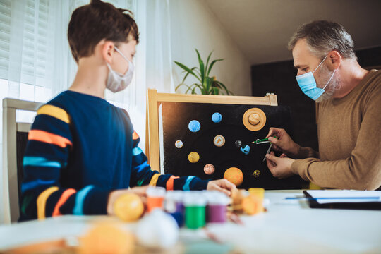 Happy School Boy And His Father Making A Solar System For A School Science Project At Home