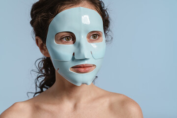 Beautiful half-naked nice girl posing with facial mask