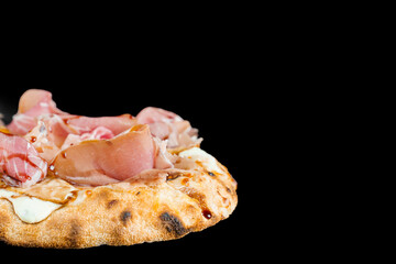 Scrocchiarella with pear, cheese, prosciutto on black background. Pinsa romana gourmet italian...