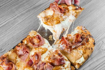 Mozzarella stretching cheese on pinsa romana gourmet italian cuisine. Food delivery from pizzeria....