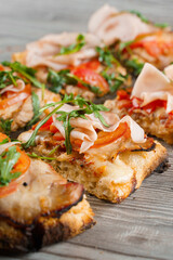 Pinsa romana cut into pieces portions for one person. Food delivery from pizzeria. Pinsa with meat,...