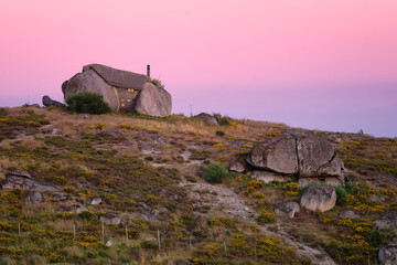 Beautiful stone Penedo Boulder House in Fafe, in Portugal at sunset