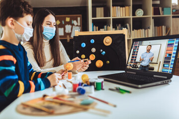 Children with protective mask presenting there science home project - the planets of our solar system. Distance learning online education.