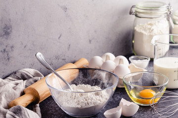 Cooking ingredients for dough, eggs, flour, sugar, milk.