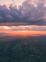 Carpathian mountains. Golden hour sunset landscape above and below rushing clouds over the mountains