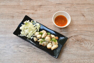 fried squid egg or gonad with chop fresh cabbage on plate dipping spicy and sour sauce