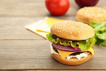 Homemade burger ingredients arranged on grey wooden background.