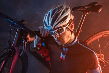 Fototapeta na wymiar Spost background with copyspace. Cyclist. Dramatic colorful close-up portrait.