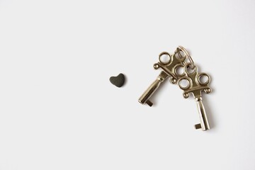 Keys to the Heart of Stone. Keys and heart shaped stone on white background.