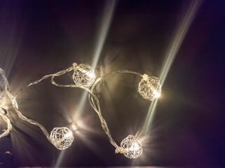 Photo of New Year's lighting on a black background. Awesome garland decoration. Festive decoration for Christmas and New Year. Low key. View from above.