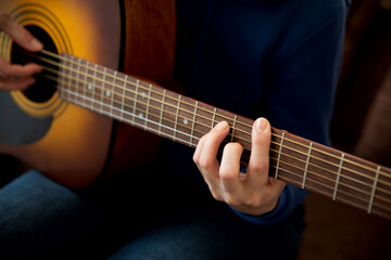Close-up woman playing acoustic guitar. Selective focus