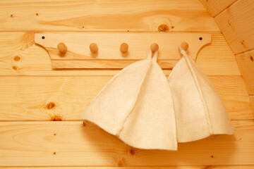 white hats for a bath on a hanger in a sauna 