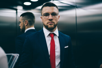 Confident businessman  in suit standing in office elevator