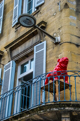 Ventana abierta y adorno de perro rojo en el balcón