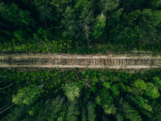 Aerial view of empty railway track through green forest in Finland