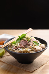Rice noodle soup with pork, pork ball and vegetables in a bowl, Thai noodles soup
