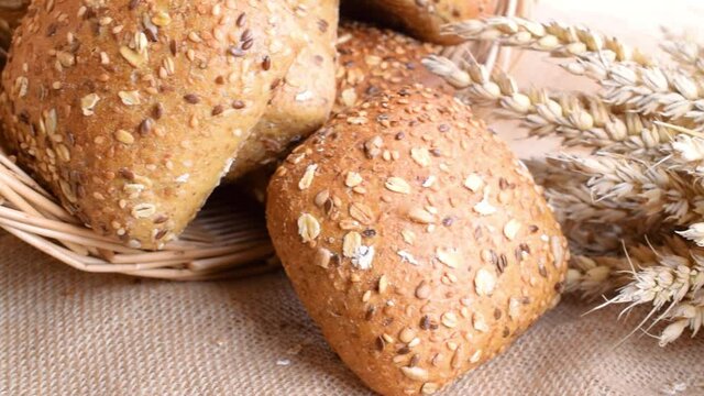 Rustic bread. Fresh loaf of rustic traditional bread with wheat grain ear or spike plant on linen texture background. Rye bakery with crusty loaves and crumbs. Concept - Cooking at Home