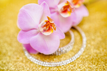 Fototapeta na wymiar Bracelet and necklace on a gold shiny background 